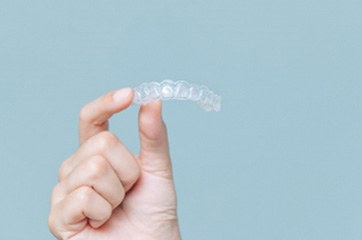 Patient holding Invisalign clear aligner