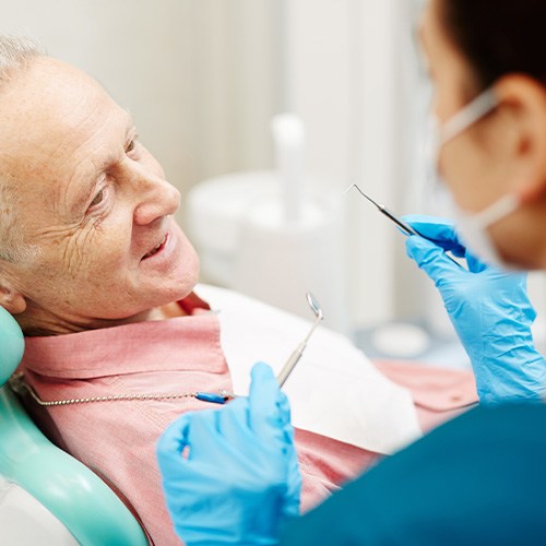 Man having his smile checked while wearing dentures in Fort Myers 