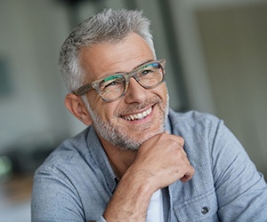 A middle-aged man smiling and pleased with his beautifully crafted dental implant restoration