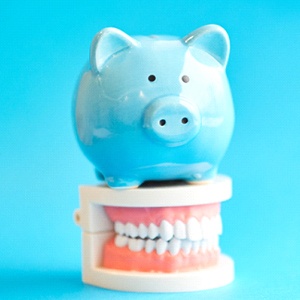 Piggy bank on top of model of dentures in Fort Myers