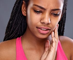 Woman with toothache holding jaw
