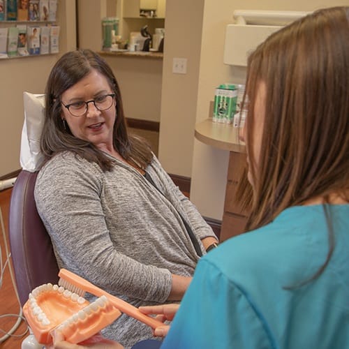 Woman talking to dental team member about preventive dentistry