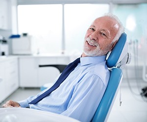 Older man smiling in dental chair