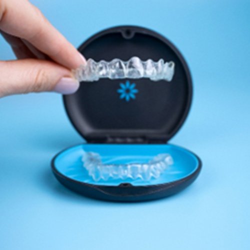 Patient placing Invisalign aligners in storage case