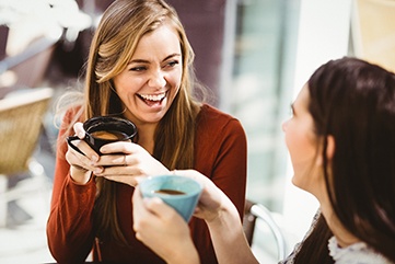 Friends smiling while enjoying coffee together