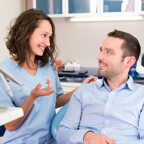 A dentist talking to her male patient about root canals