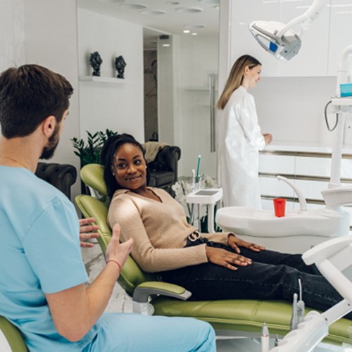 Woman smiling at dentist while sitting in treatment chair