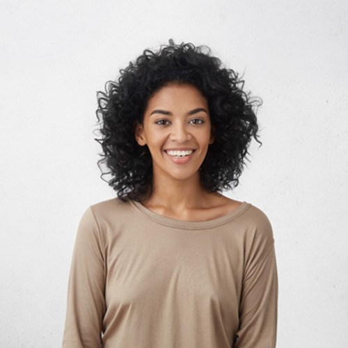 Close-up of a woman standing up and smiling after teeth whitening in Fort Myers, FL