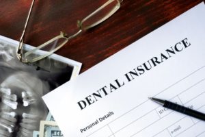 Dental insurance form on desk next to glasses