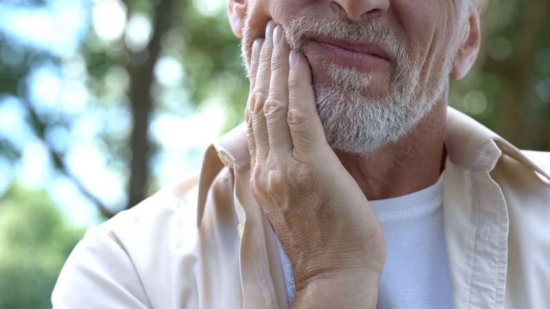 Closeup of man experiencing sensitivity in dental implant