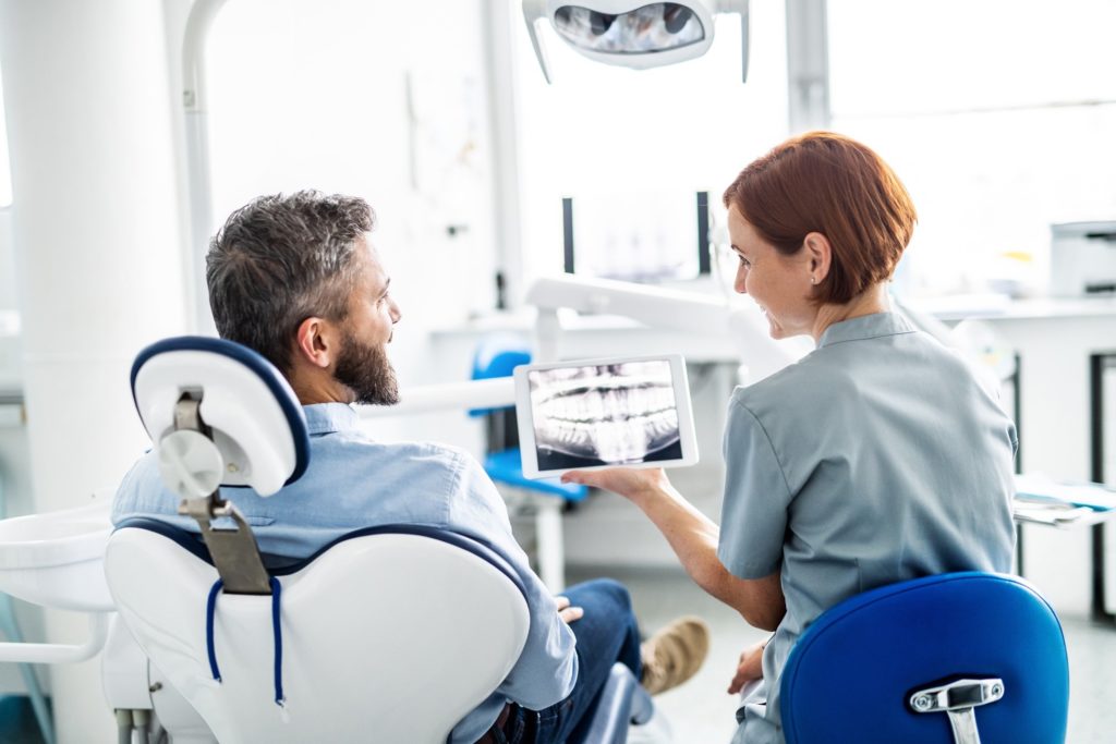 Implant dentist showing patient X-ray