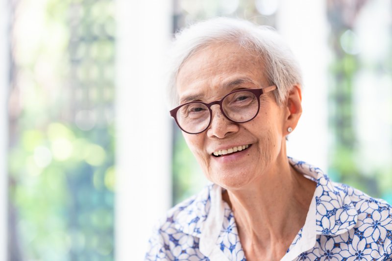 patient smiling after having ill-fitting dentures fixed