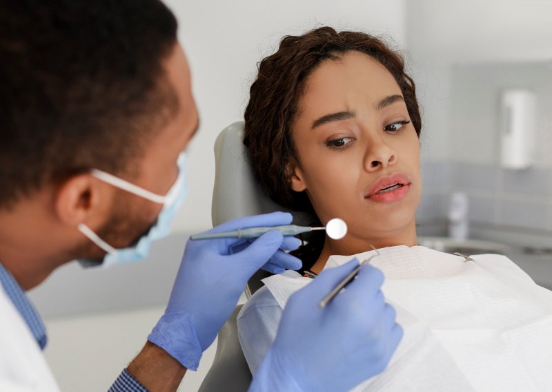 A frightened woman receiving dental care