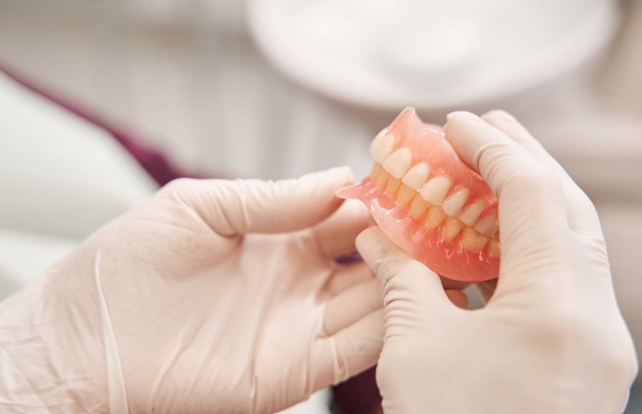 Dentist holding dentures.